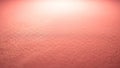 Close up macro shot of a textured coral pink surface with soft lighting creating a gradient effect from dark to Royalty Free Stock Photo