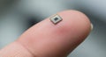 Tiny Microchip on Human Finger Macro. Royalty Free Stock Photo