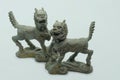 Close-up macro shot of a male and female bronze Chinese Qilin figurines, on white background