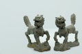 Close-up of a pair of Chinese bronze Qilin figurines, with a dragon head, deer antlers, fish scales, ox hooves & lion tail