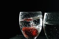 Close up, macro. Strawberries submerged with a splash in a sizzling drink. Isolated on black background Royalty Free Stock Photo