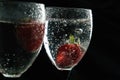 Close up, macro. Strawberry floating in a alcoholic drink with bubbles. Isolated on black background Royalty Free Stock Photo