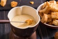 Close up. Traditional french cheese fondue. Crouton dipped into hot fondue with gruyere on a long-stemmed fork. Royalty Free Stock Photo