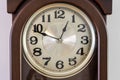 Close up macro view of brown clock with light clock face showing almost twelve fifty o`clock. Time concept. Royalty Free Stock Photo