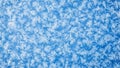 Close up macro view of intricate ice crystals forming delicate snowflake patterns on a vibrant blue background Royalty Free Stock Photo