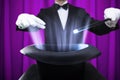 Magician Holding Magic Wand Over Illuminated Hat Royalty Free Stock Photo