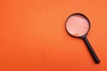 Close up Magnifying glass  on a orange background Royalty Free Stock Photo
