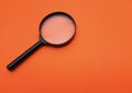 Close up Magnifying glass  on a orange background Royalty Free Stock Photo