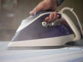 Close up maid hand in the hotel ironing clothes in hotel room white table Royalty Free Stock Photo