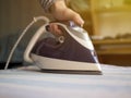 Close up maid hand in the hotel ironing clothes in hotel room white table Royalty Free Stock Photo