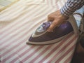 Close up maid ironing clothes in hotel cozy room Royalty Free Stock Photo