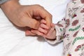 Close up and main focus on newborn baby hand is holding the finger of her mother Royalty Free Stock Photo