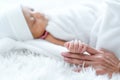 Close up and main focus on newborn baby hand is holding the finger of her mother on bed Royalty Free Stock Photo