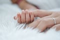 Close up and main focus on newborn baby hand is holding the finger of her mother on bed Royalty Free Stock Photo