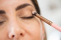 Close-up of a make-up artist applying eye shadow to her client. Royalty Free Stock Photo