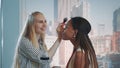 Close-up of make-up artist applying makeup on black model with skyscrapers in the background Royalty Free Stock Photo