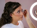 Close up of a make up artist doing bridal makeup on beautiful caucasian woman
