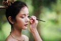 Close up Makeup artist applies eye shadow . Beautiful woman with make-up face. Hand of visagiste, painting cosmetics of young Royalty Free Stock Photo