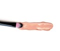 Close-up of makeup brush with smeared liquid foundation on white background. Top view.