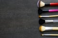 Close up of makeup brushes on black background