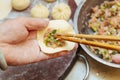 A close-up of making fresh meat buns and filling them with meat by hand.