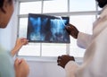 Close up male abdominal x-ray, held by two doctors reviewing medical treatment Royalty Free Stock Photo