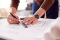 Close Up Of Male Architect In Office Drawing On Plan Or Blueprint With Ruler