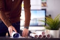 Close Up Of Male Architect In Office Unrolling Building Plan Or Blueprint On Desk Royalty Free Stock Photo