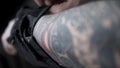 Close up of the male arm with black tattoo and a man putting on black old arm warmer, art concept. Action. Man with a