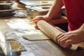 Close up of male baker hands with flour cook roll out the dough with rolling pin Royalty Free Stock Photo