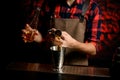 Close-up male barman pours cocktail from bowl into metal martini glass. Royalty Free Stock Photo