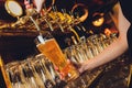 Close up of a male bartender dispensing draught beer in a pub holding large glass tankard under a spigot attachment on a Royalty Free Stock Photo