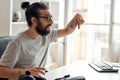 Close up of male blogger pointing down, asking followers to subcribe, while recording video blog or vlog at home studio