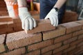 Male builder hands making make brickwork using red bricks Royalty Free Stock Photo