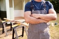 Close Up Of Male Carpenter Building Outdoor Summerhouse In Garden