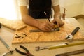 Close-up of male carpenter hands drawing mark on wooden flooring Royalty Free Stock Photo