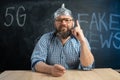 close-up of a male conspiracy theorist in a protective foil cap and glasses debunks myths. Conspiracy theory and the