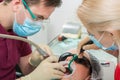 Close-up of a male dentist and his assistant in medical disposable gloves doing a procedure for polishing teeth for cleaning from Royalty Free Stock Photo