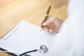 Close-up Of Male Doctor Filling The Medical Form. Doctor man writting a paper in clinic workplace.. Royalty Free Stock Photo