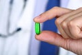 Close up of male doctor hand holding green softgel capsule Royalty Free Stock Photo