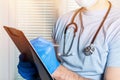 close up of male doctor holding prescription paper in hand