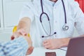 Close up of a male doctor shaking hands with his male patient. Medicine and trust concept