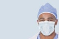 Close-up of a male doctor wearing facemask over light blue background Royalty Free Stock Photo