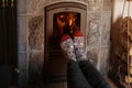 close up of male feet legs in colored woolen socks are warming near flame, firewood burns in stove, fireplace, cozy winter evening Royalty Free Stock Photo