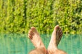 Close up of male feet over resort swimming pool Royalty Free Stock Photo