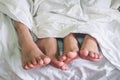Close up of male and female feet on a bed Royalty Free Stock Photo