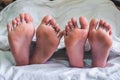 Close up of male and female feet on a bed and couple having sex Royalty Free Stock Photo