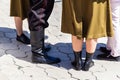Close-up of male and female legs, dressed in military uniforms, stand in a circle on paving slabs. Royalty Free Stock Photo
