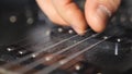 Close up of male fingers touching strings of a musical instrument. Chords being strummed and vibrating. Hand of man