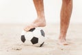 Close-up of male foot playing football on sand. Royalty Free Stock Photo